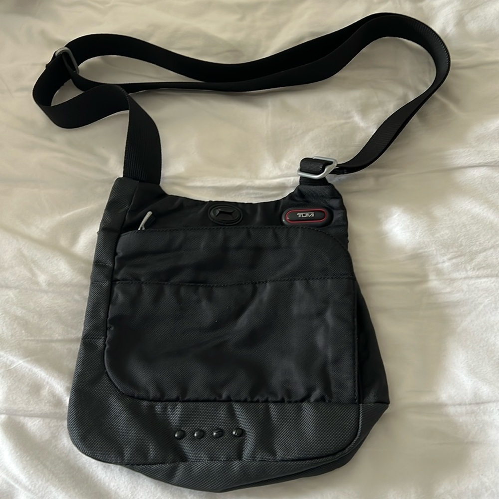Tumi Black travel bag with red interior, light and adjustable strap